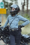 Person wearing a helmet and jacket standing next to a motorcycle on a social media platform.