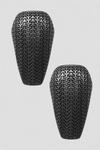 Two black elbow and knee guards with textured surface on a light gray background