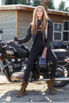 Woman sitting on a motorcycle wearing a Stellar moto brand black jacket and pants with a helmet.